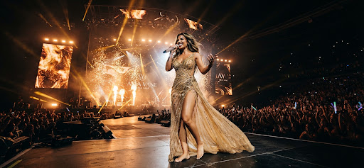 Aria Vane on stage in a golden couture gown